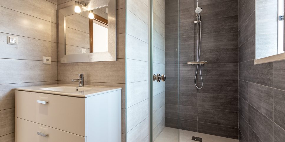 Modern bathroom with shower and washbasin for hygiene.